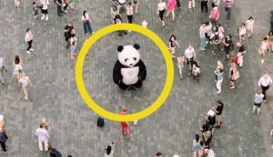 un individuo disfrazado de oso panda en medio de una multitud