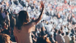 chica joven en un concierto levantando la mano